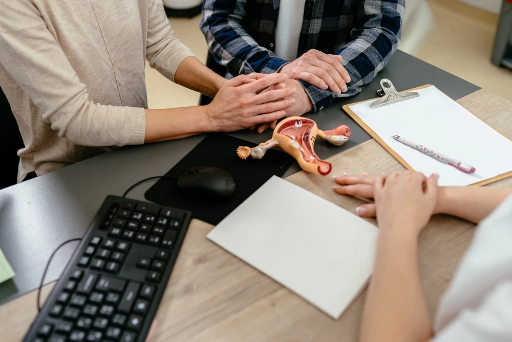 Family, wellness and infertility consultation. Female doctor consulting unrecognizable mature couple patients in fertility clinic about IVF or IUI