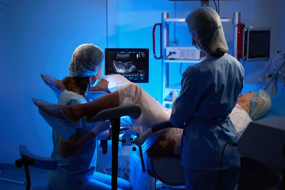 Female doctor and nurse doing embryo transfer for woman patient